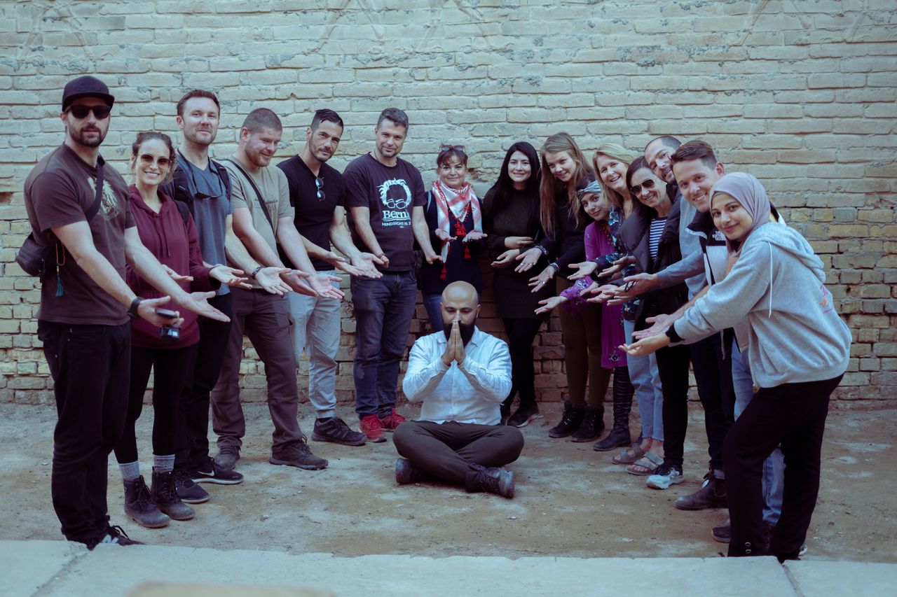 A diverse group of friends playfully posing together in Baghdad, Iraq, showcasing unity and joy.