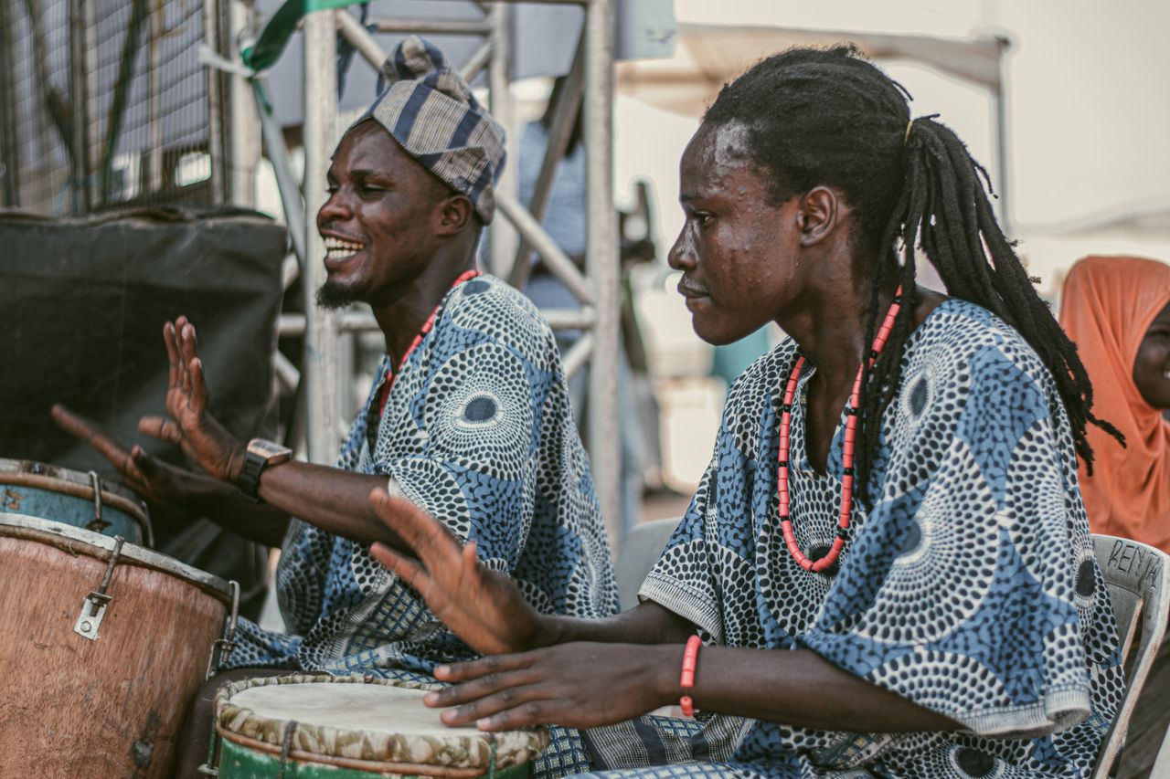 Traditional musicians performing at a cultural festival in Ilorin, Nigeria, showcasing vibrant African drums and attire.